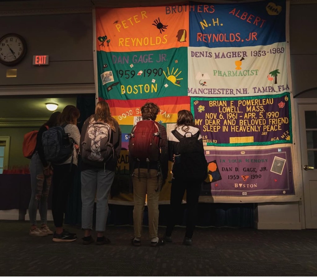 College students look up at the panels on the AIDS Memorial Quilt.